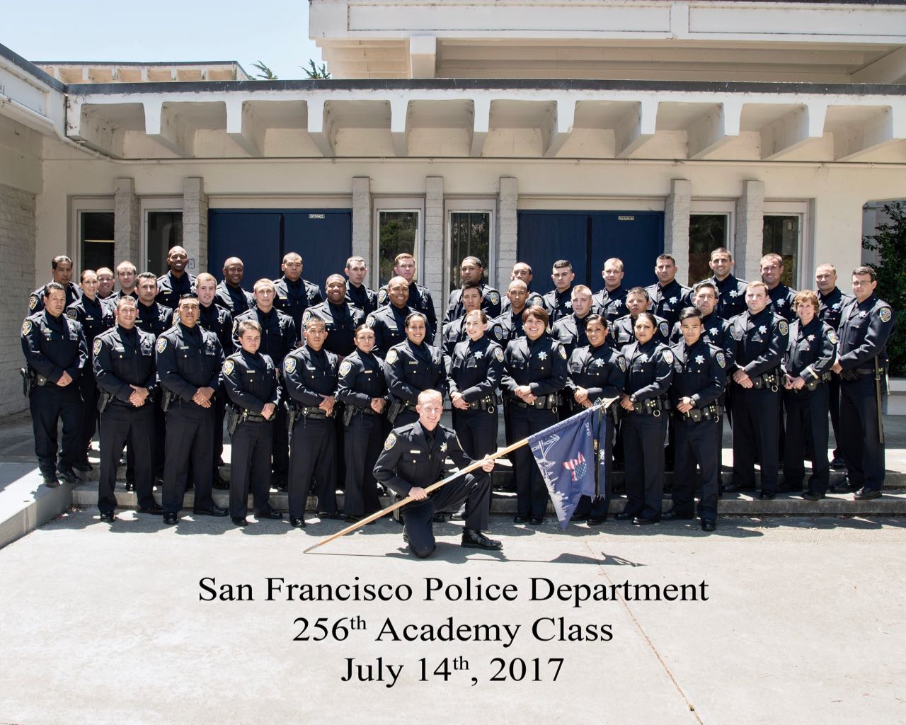 Photo of academy class in police uniform standing.