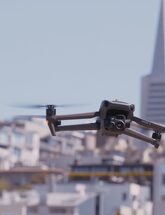 Image of department drone hovering in the air with city skyline in the background